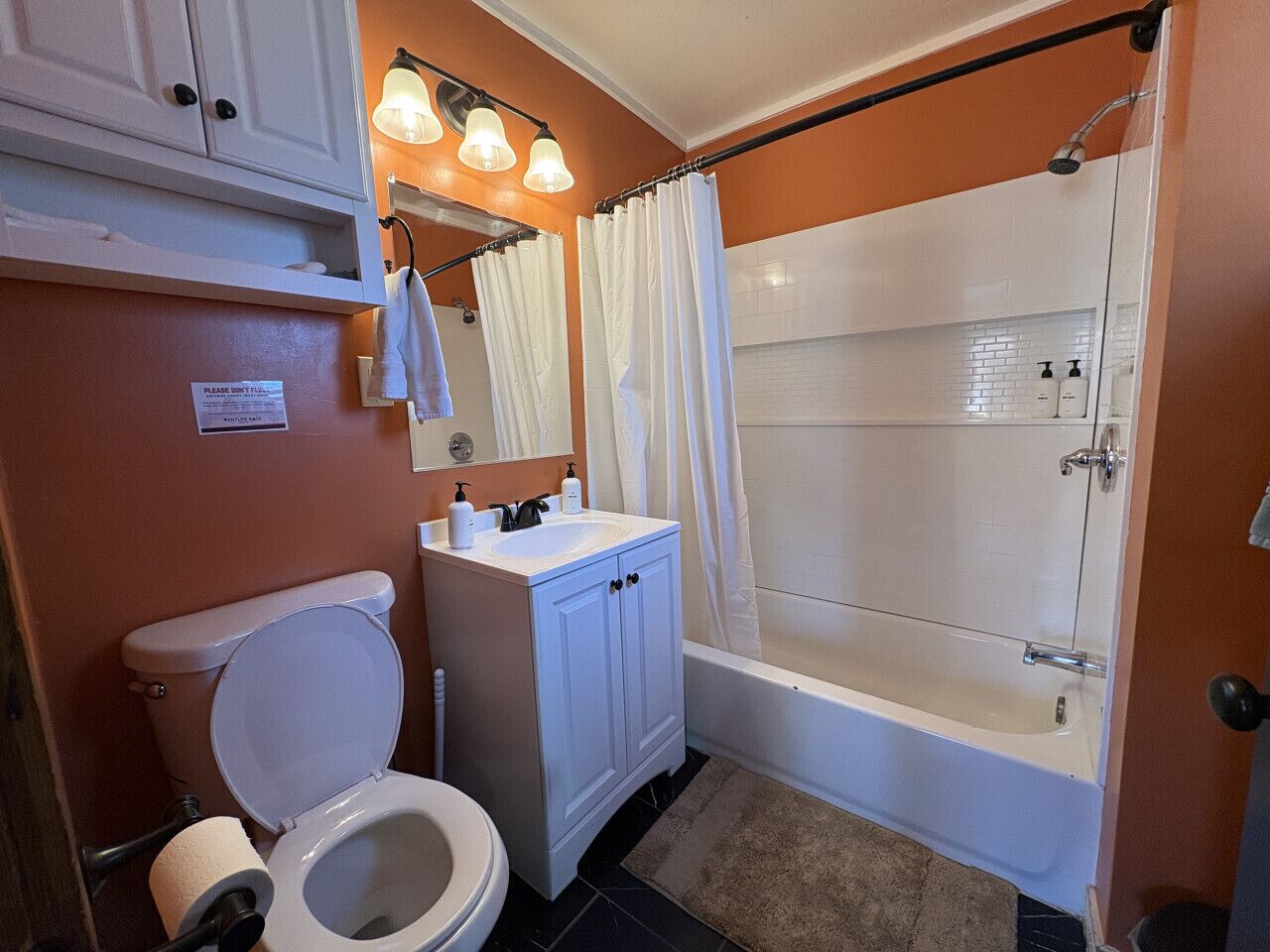 A bathroom with a toilet, sink, and shower.