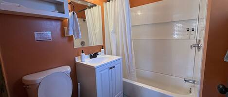 A bathroom with a toilet, sink, and shower.