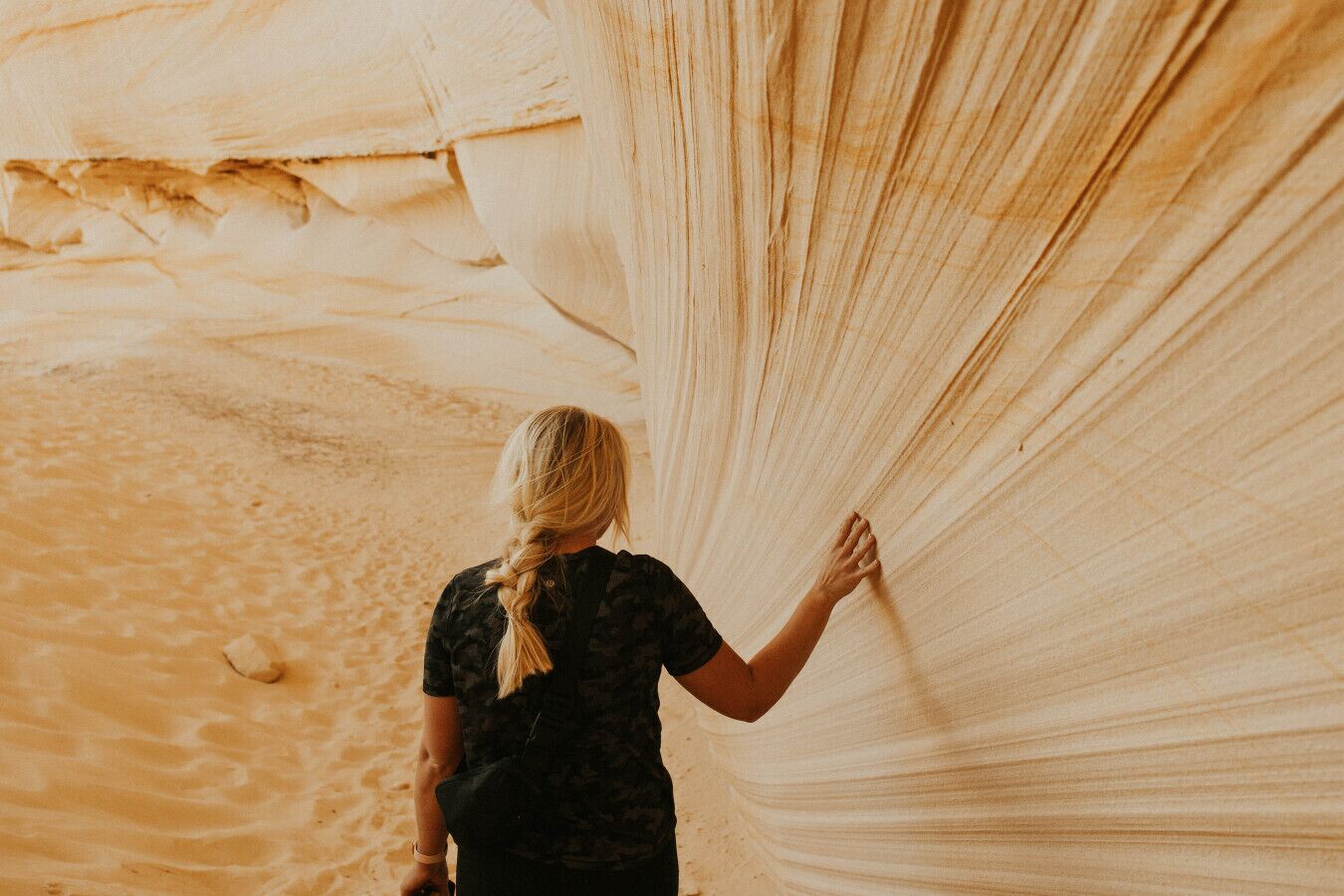 A person standing in a narrow canyon with smooth, light-colored rock walls.