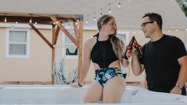 A couple in a hot tub with string lights in the background. - Downtown Kanab • Family & Pet Friendly • Hot Tub (Kanab)