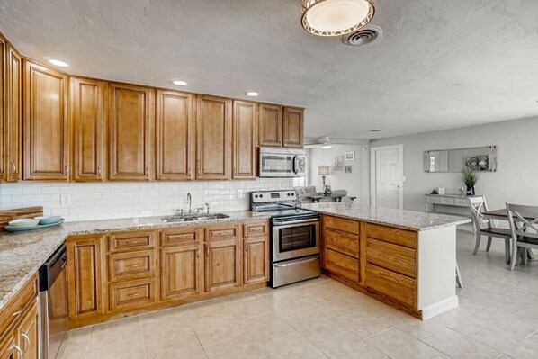 Enjoy cooking in this well-equipped kitchen with a large island, stove, oven, and microwave.