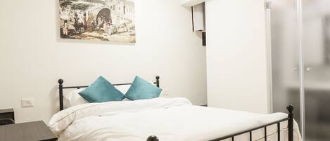 Een slaapkamer met een bed, een bureau en een stoel.
