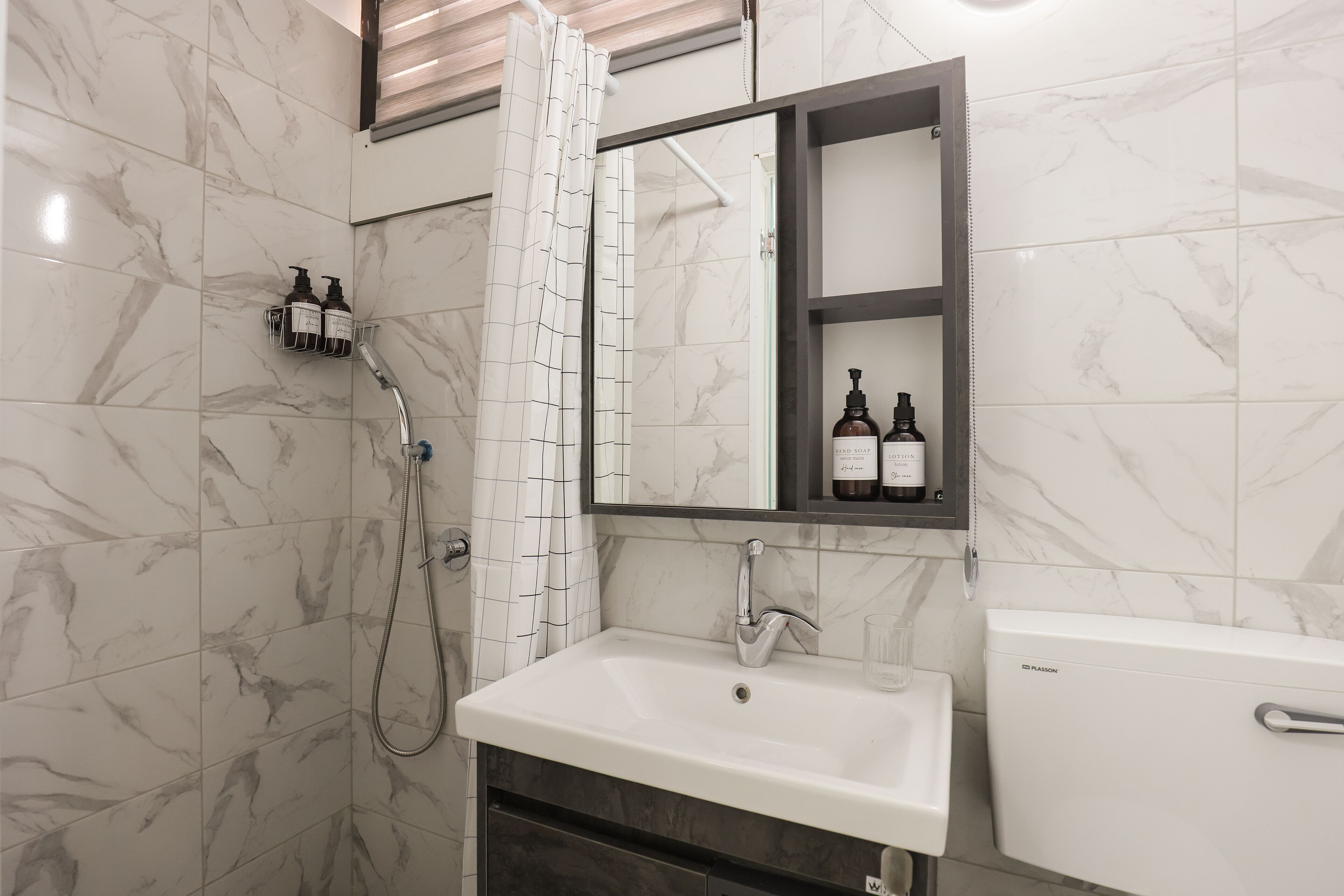 A bathroom with a white sink, a mirror cabinet, and a toilet.