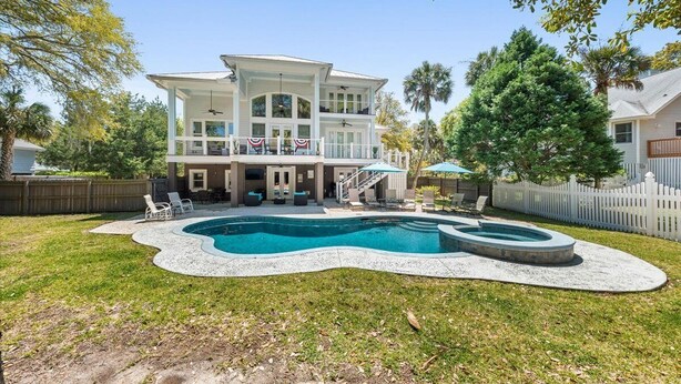 Ein zweistöckiges Haus mit großem Garten, inklusive Pool und Whirlpool.