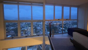 Habitació d'un hotel alt amb grans finestres i vistes a la ciutat.