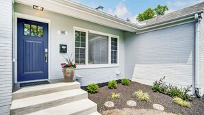 A house with a blue door, a number 181 sign, a window with blinds, and a small garden with stepping stones and plants. - Completely updated home! -Close to hospitals, UD, Wright Patt Air Force Base. (Kettering)