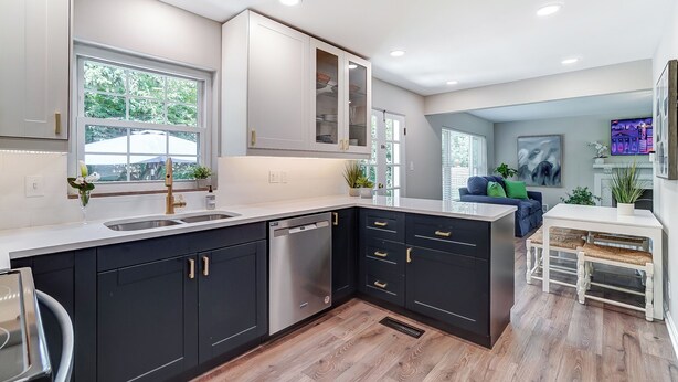 A modern kitchen with dark cabinets, stainless steel appliances, and a large window. - Completely updated home! -Close to hospitals, UD, Wright Patt Air Force Base. (Kettering)