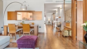 A modern living room with a dining area, wooden flooring, and a large mirror. - Apartment in Playas del Duque for 6 people| Casa Granada 146 (Puerto Banús - Marbella)