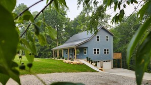 A two-story house with a covered porch, a garage, and a driveway leading to the entrance. - Quiet cabin 30 min from wineries, restaurants, Sugar Creek & Walnut Creek.  (Fresno)