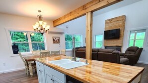 A modern kitchen with a wooden countertop, white cabinets, and a dishwasher. - Quiet cabin 30 min from wineries, restaurants, Sugar Creek & Walnut Creek.  (Fresno)