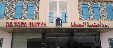 The entrance to Al Safa Suites with a modern design, featuring a central logo and bilingual signage in English and Arabic.