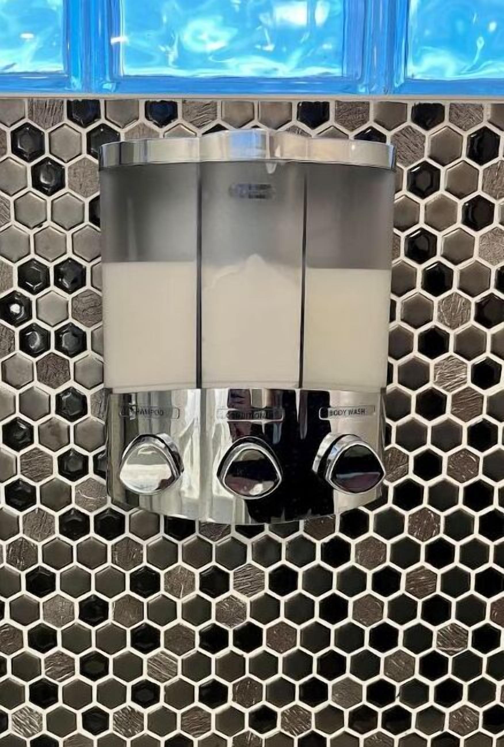 A bathroom with a hexagonal tile backsplash and a modern faucet with multiple spray heads.