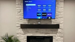 A flat-screen TV mounted on a stone wall above a fireplace. - Country Retreat One (North Tonawanda)