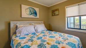 A bedroom with a bed, a window, and a wall with a painting and a sign. - North Topsail Beach Vacation Rental w/ Balcony! (North Topsail Beach)