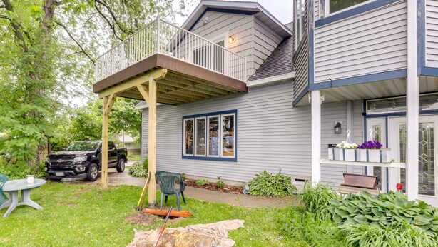 Ein Haus mit überdachter Veranda, Garage und gepflegtem Rasen.
