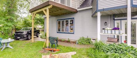 A house with a covered porch, a garage, and a well-maintained lawn.