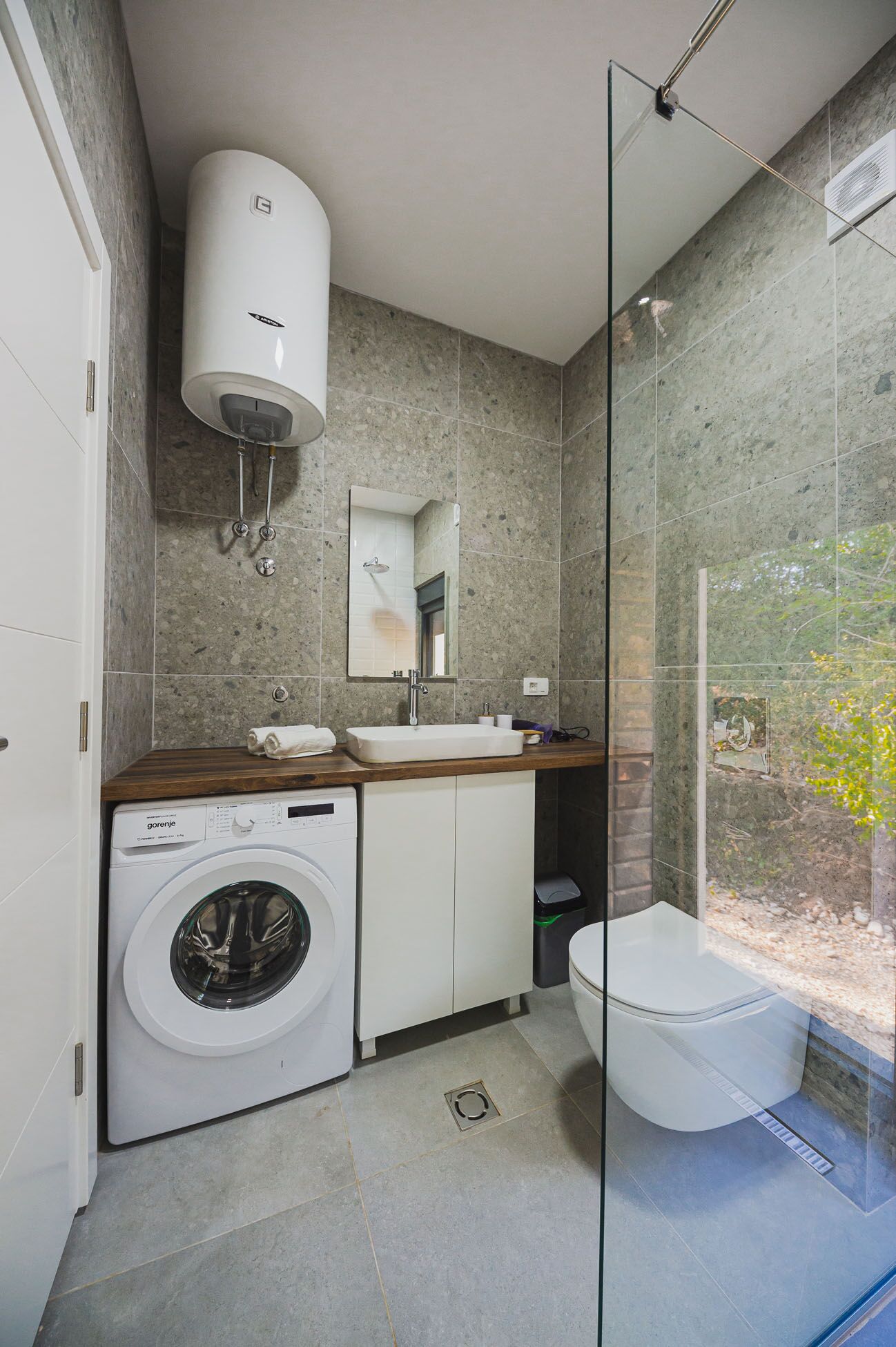 Un baño pequeño con lavadora, lavamanos e inodoro.