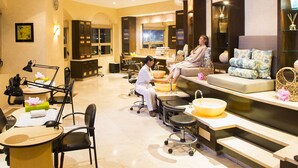 A well-lit spa room with a reception desk, seating area, and a large window. - BISBEE WEEK (Cabo San Lucas)
