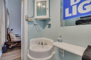 Bathroom features a sink with two faucets and a mirror.