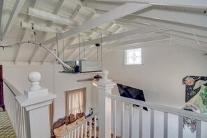 Cozy retreat with a fireplace, exposed beams, and a balcony view.