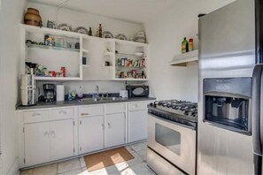 Kitchen features a gas stove, sink, and refrigerator, with ample storage for kitchen essentials.