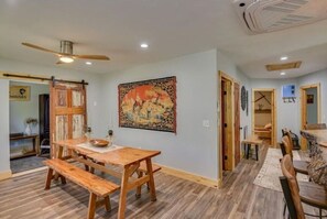 Enjoy meals in this cozy dining area with a rustic table and benches, surrounded by a large tapestry.