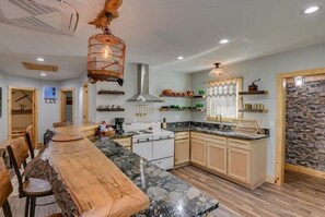 Enjoy cooking in this well-equipped kitchen with a central island, stove, and ample counter space.