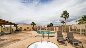 A pool area with lounge chairs and palm trees. - Pet-Friendly Needles Vacation Rental Near River! (Needles)