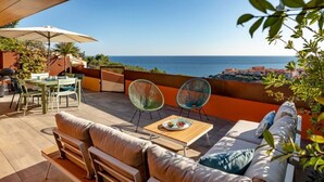 Eine Terrasse im Freien mit einer Couch, Sesseln und einem Tisch.