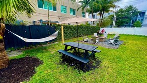 A backyard with a picnic table, chairs, a hammock, and a pool. - Moody Stoody-O Near Las Olas Beach & Holiday Park (Fort Lauderdale)