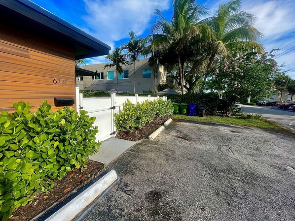 A residential area with a house number 618, a driveway, and a small garden with shrubs.