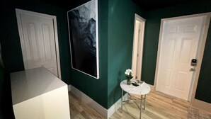 A hallway with green walls, white doors, and a marble-topped table with a vase of flowers. - Moody Stoody-O Near Las Olas Beach & Holiday Park (Fort Lauderdale)