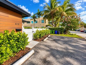 A residential building with a number '618' on the side, surrounded by well-maintained greenery and a clear sky.
