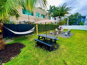 A backyard with a picnic table, chairs, a hammock, and a pool. - Moody Stoody-O Near Las Olas Beach & Holiday Park (Fort Lauderdale)