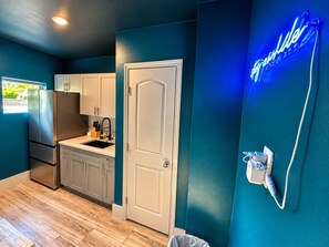A kitchen with a stainless steel refrigerator, a sink, and cabinets.