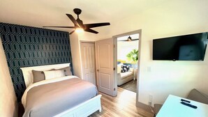 A bedroom with a bed, a ceiling fan, a TV, and a desk. - Bahama Mama 2/1 in Las Olas & Holiday Park with Hot Tub! (Fort Lauderdale)
