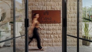 La entrada de un edificio con un letrero que dice "casa" y una persona caminando.