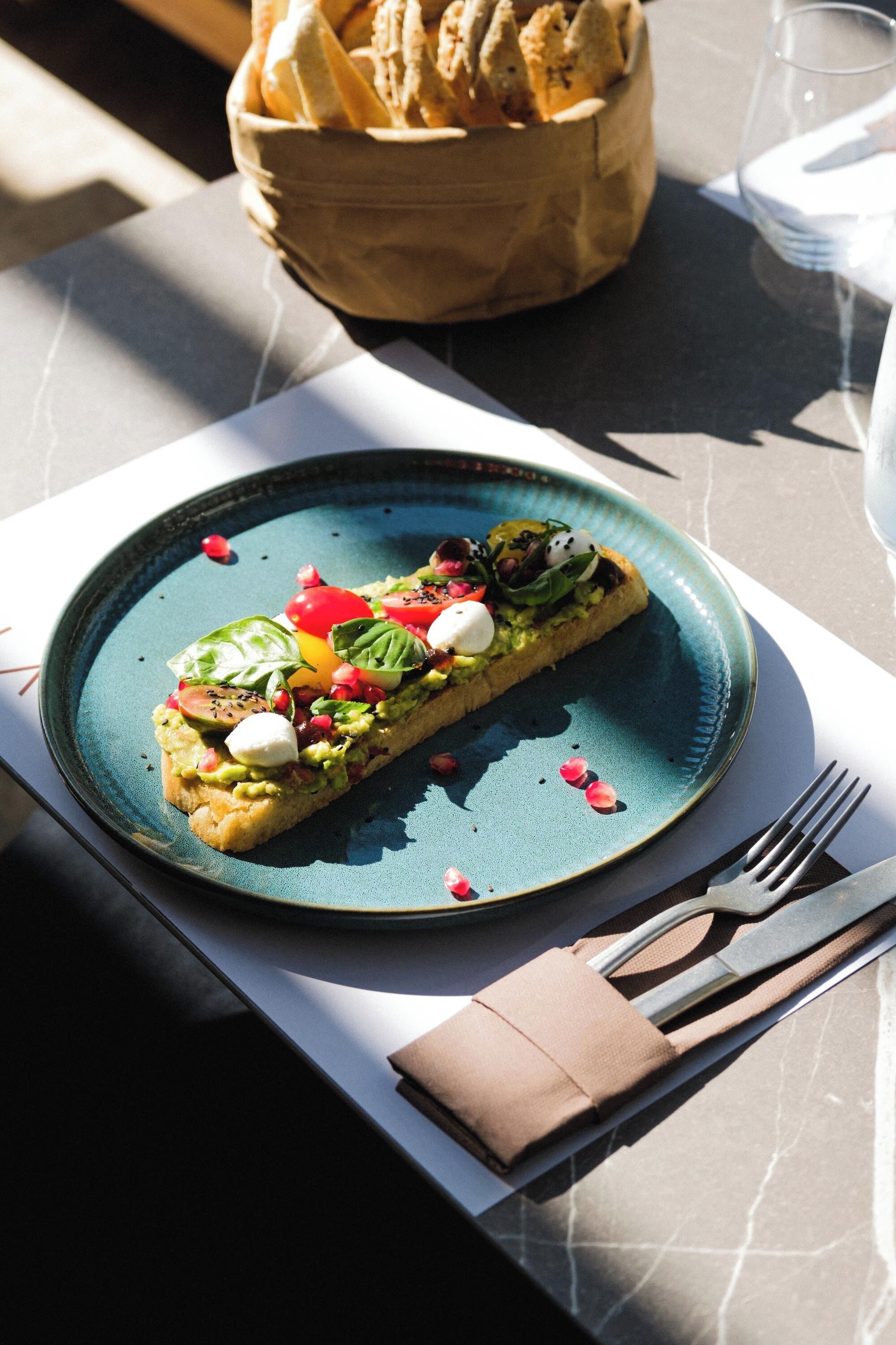 A meal on a blue plate with a napkin and cutlery beside it.