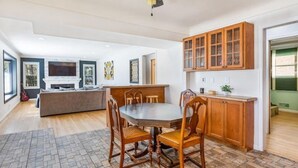 A spacious kitchen with a dining area, wooden cabinets, and a large island. - Spacious 3 BR Modern Home in Grosse Pointe Park (Grosse Pointe Park)