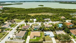 Luchtbeeld van een woongebied met huizen, wegen en een waterpartij op de achtergrond.