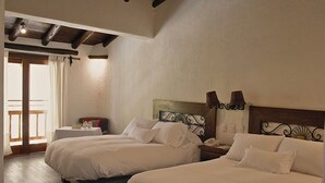 Ein Hotelzimmer mit zwei Betten, einem kleinen Tisch mit Lampe und Blick nach draußen.