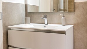 A bathroom with a white sink, a mirror, and two soap dispensers. - P011 - Porto Recanati, new studio facing the sea (Porto Recanati)