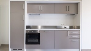 A compact kitchen with a built-in oven, stainless steel cabinets, and a sink. - A31 - Ancona, new studio apartment in the centre (Ancona)