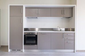 Een koelkast, een oven, een vaatwasser, eettafels