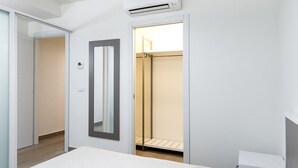 A bedroom with a bed, a wardrobe, a mirror, and an air conditioning unit. - A31 - Ancona, new studio apartment in the centre (Ancona)