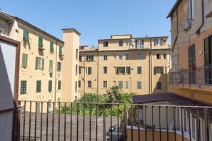 A multi-story building with balconies, a courtyard, and a clear sky.