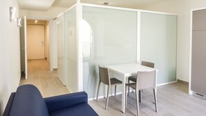 A modern room with a sofa, a dining table with chairs, and a partition wall. - A31 - Ancona, new studio apartment in the centre (Ancona)