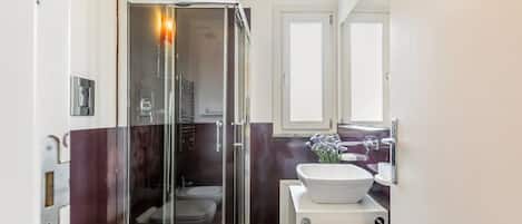 Regadera, secadora de cabello, bidet, toallas