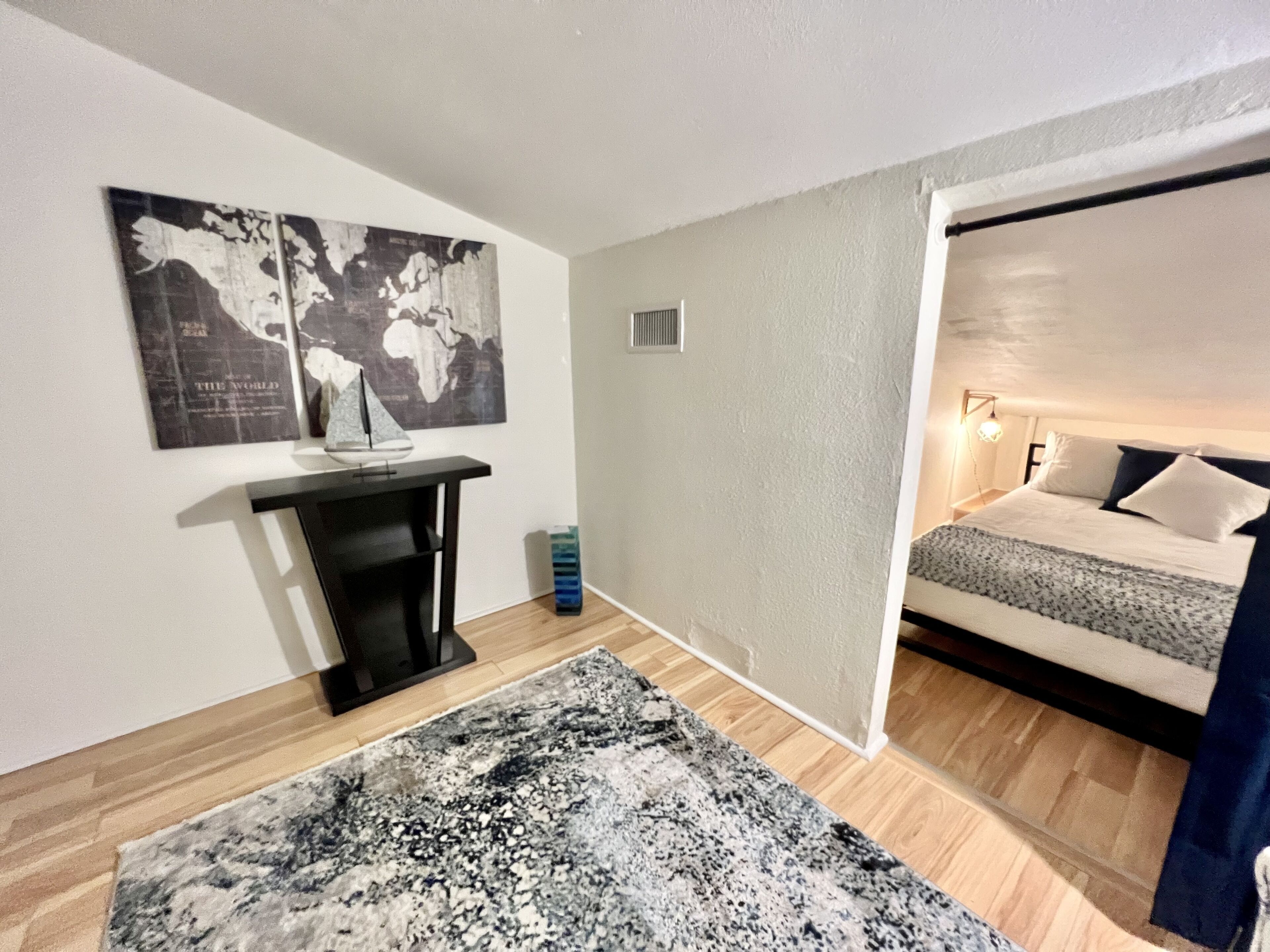 Una camera da letto con un letto, una scrivania e un grande tappeto.