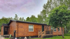 A log cabin with a front porch, a small deck, and a garden area. - Haywire Haus, Pictured Rocks, Hot Tub, ORV Trail (Shingleton)